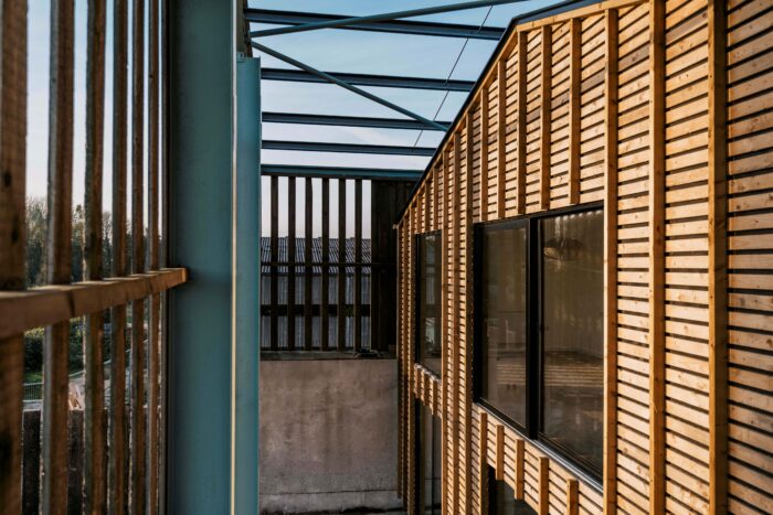 THe house is build inside the modern barn, but independant of it. THe steel frame of the barn is evident, with sections of roof and cladding remaining. The house is clad in timber , some of which was salvaged from the barn.