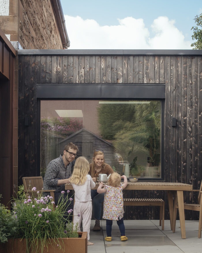 The family in the garden in front of the newly clad extension