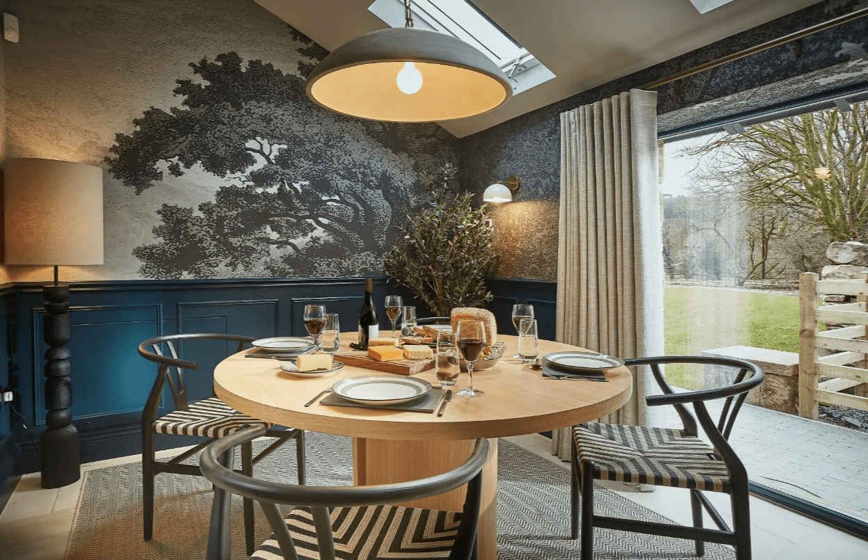The coach house dining area also has nature-inspired wallpaper and huge windows.